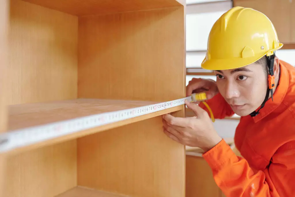 stock-photo-workman-measuring-shelves